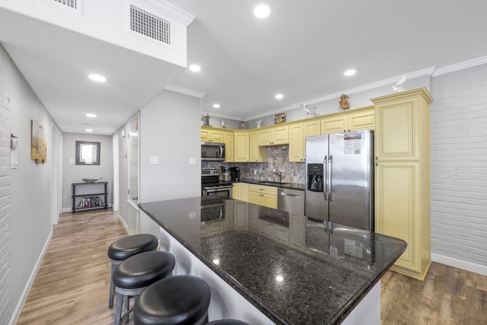 Your fully equipped kitchen features granite countertops, stainless appliances, and a breakfast bar where you can enjoy morning coffee.