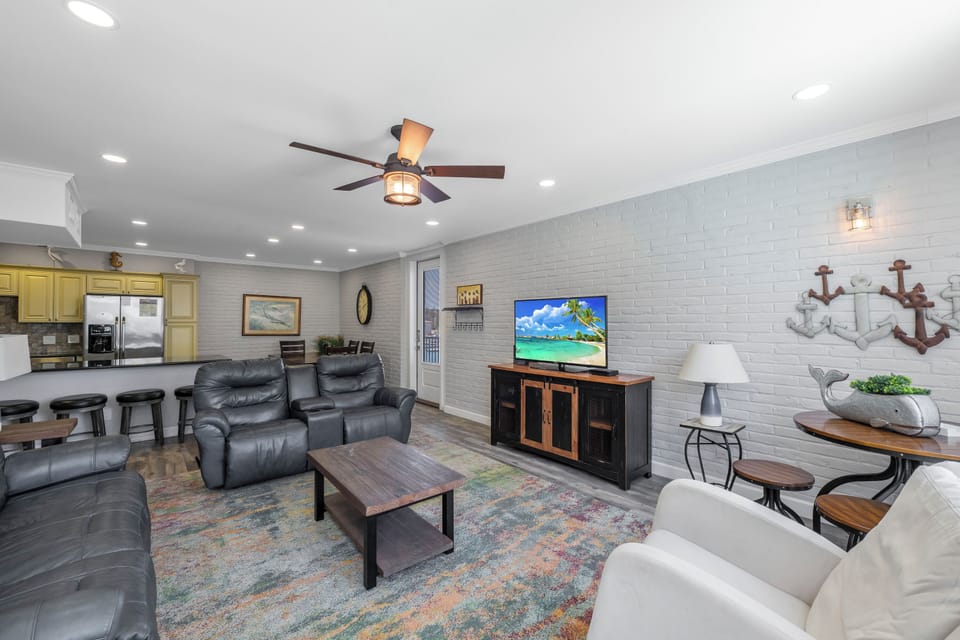 Your spacious open-concept living area features plush leather seating, smart TV, and kitchen access for perfect vacation relaxation.