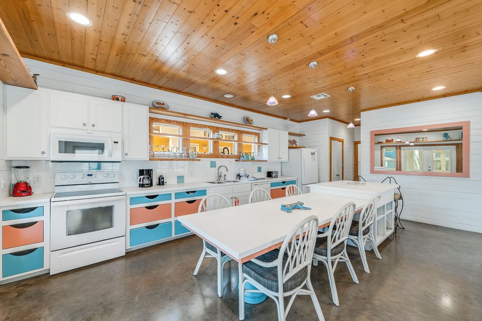 Your spacious kitchen features warm wood ceilings, colorful accents, and a large dining table perfect for family meals and group gatherings.