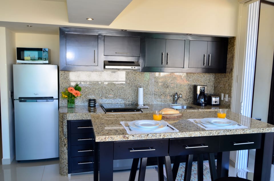 Granite kitchen and bar opens to brook side balcony.