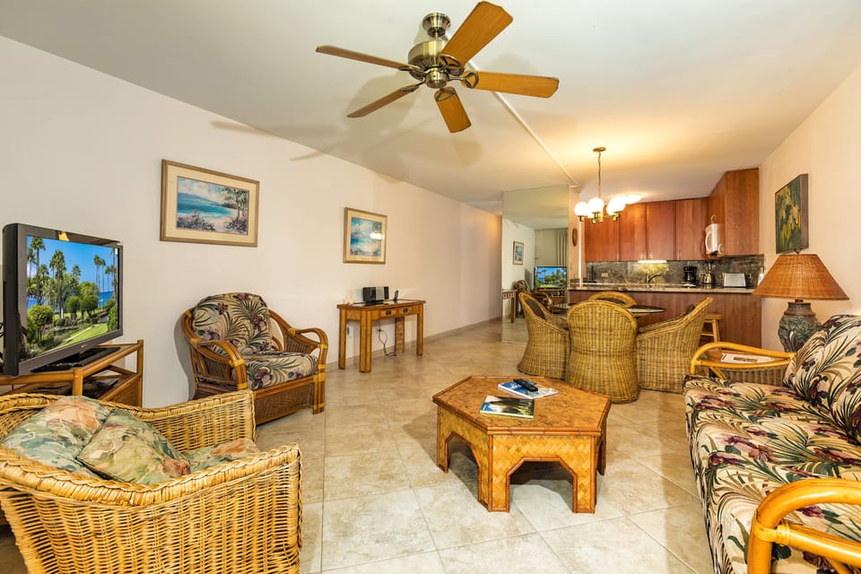 Unwind in your tropical-inspired living space with comfortable wicker seating, ceiling fan, and full kitchen—perfect for relaxing after beach days.