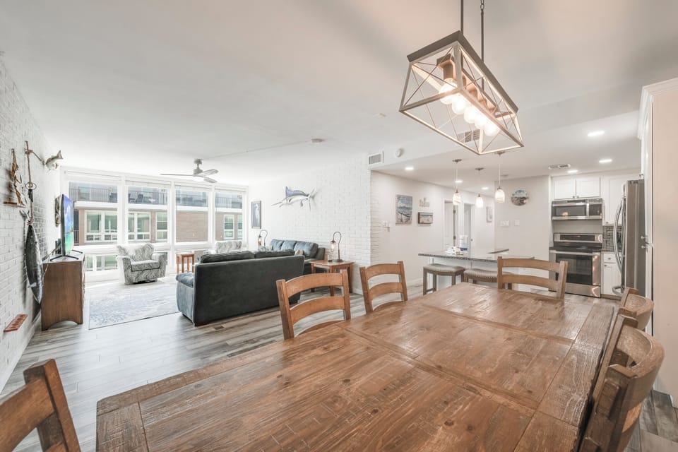 Your spacious open-concept retreat blends rustic charm with modern comfort, featuring a gorgeous dining table perfect for memorable meals together.