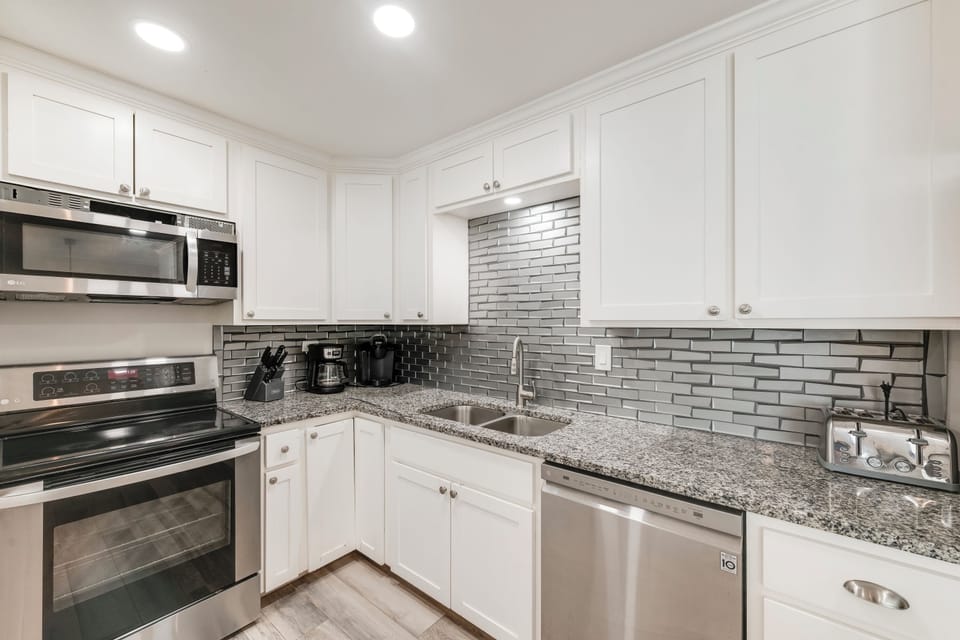 Your modern kitchen awaits with granite counters, stainless appliances, and stylish subway tile - perfect for preparing meals during your stay.