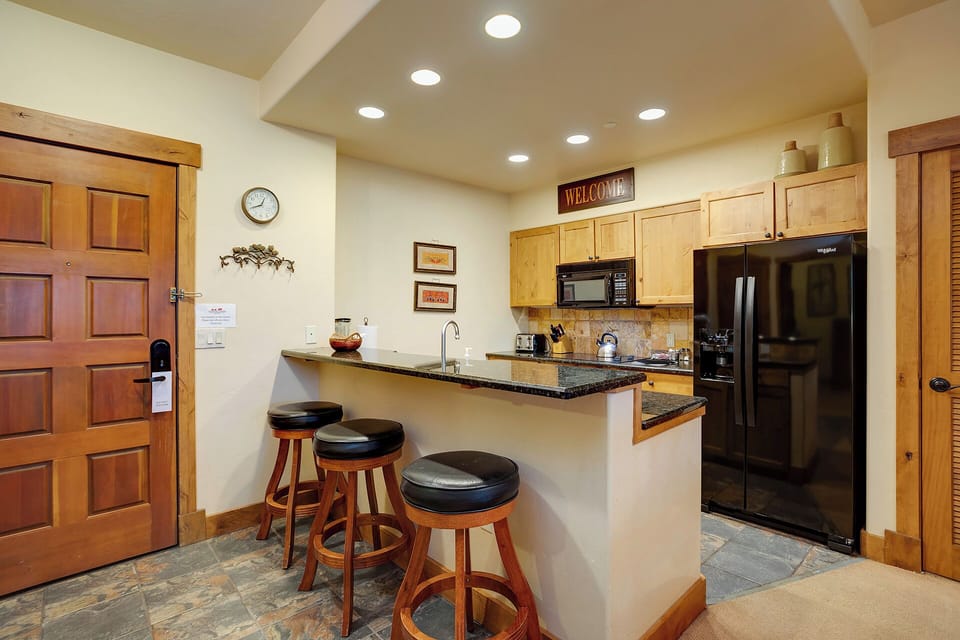 Your fully equipped kitchen welcomes you with granite counters, stainless appliances, and cozy bar seating for morning coffee or evening meals.