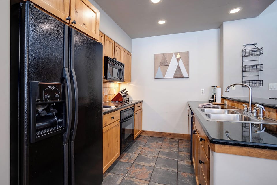Your fully equipped kitchen features granite countertops, stainless steel appliances, and warm wood cabinetry for home-cooked meals.