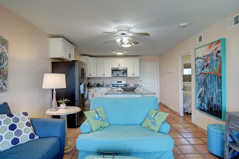 Relax in your bright coastal living room with tropical art, then whip up meals in the fully equipped kitchen just steps away.