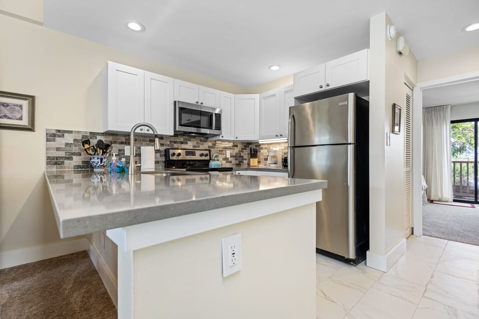 Bright, fully equipped kitchen with gleaming countertops and modern stainless steel appliances makes meal prep a breeze during your stay.