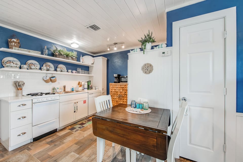 Your charming kitchen awaits with cheerful blue walls, vintage dishes, and everything needed for memorable meals together.
