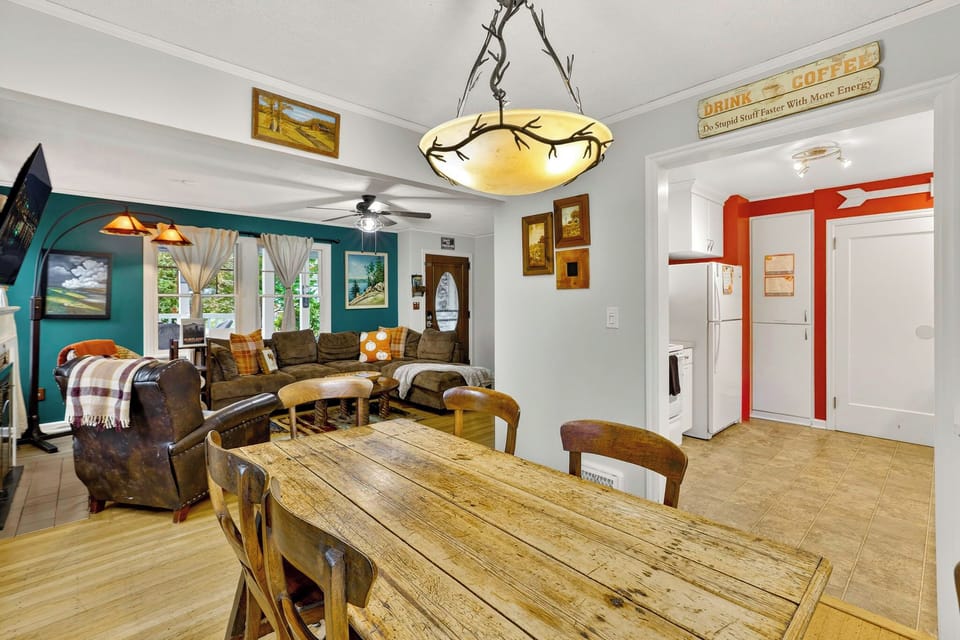 Dine at the wooden table with views of the cozy living room. A bright, inviting space perfect for meals, relaxing, and spending time with family or friends.