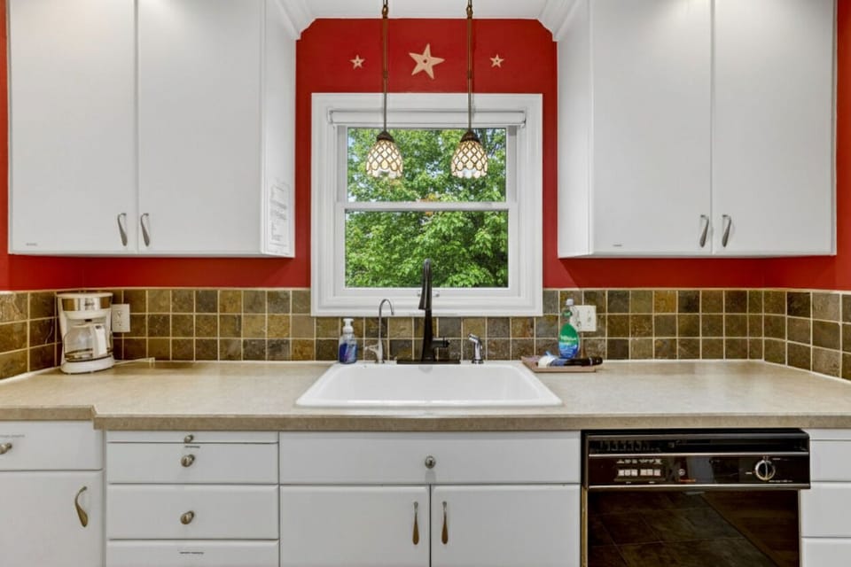 Wash up at the kitchen sink while enjoying serene views of trees and greenery through the window. A peaceful spot for morning routines or meal prep.