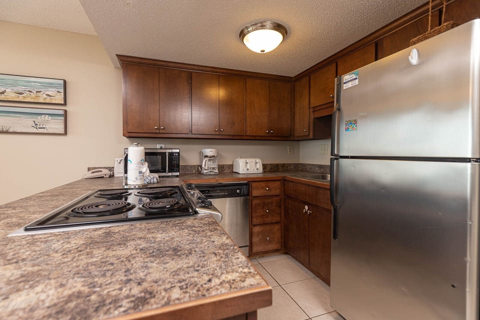 This kitchen features dark wood cabinetry, stainless appliances, and a convenient layout for meal prep and entertaining