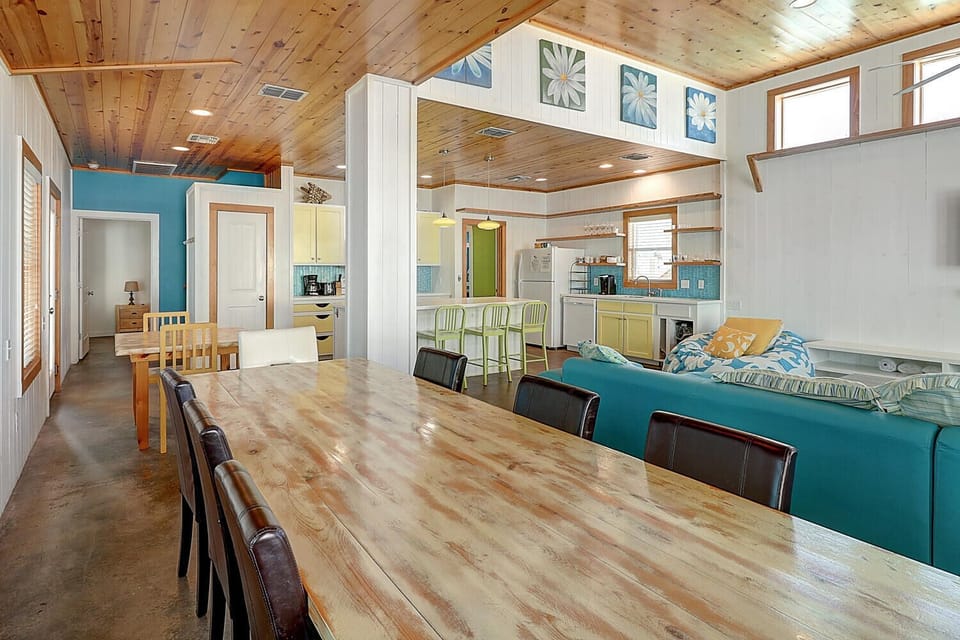 Relax in your coastal-inspired living space where rustic wood ceilings meet vibrant turquoise accents, creating the perfect beach house atmosphere.