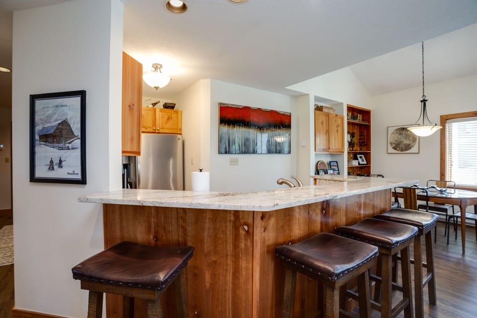 Gather around this spacious kitchen island where granite countertops and leather bar stools create the perfect spot for your morning coffee conversations.