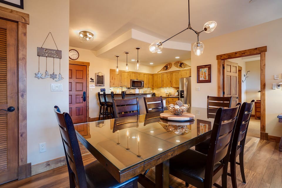 Gather around the elegant glass dining table where memorable meals and conversations await in your mountain retreat.