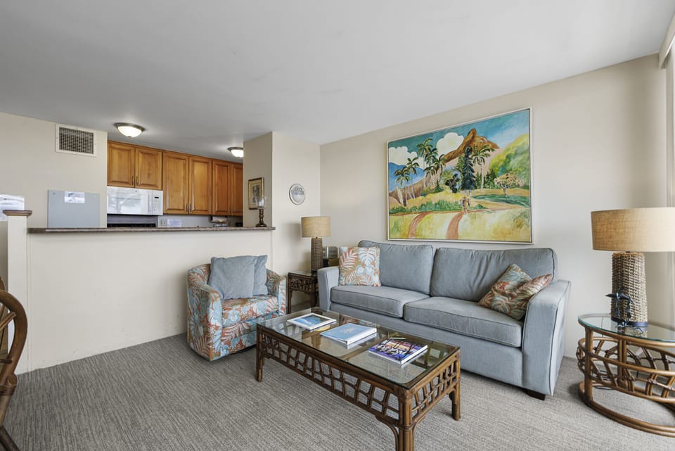 Relax in your spacious living room with vibrant artwork and comfortable seating, seamlessly connected to your fully equipped kitchen—perfect for unwinding after a day of adventure.