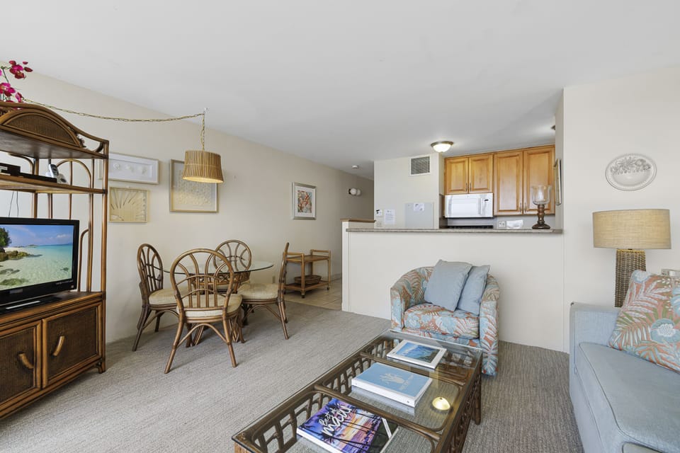 Relax in your bright, coastal-inspired living space with beachy rattan furniture, tropical prints, and an open kitchen. Your home-away-from-home awaits with soft seating, natural light, and island charm throughout.