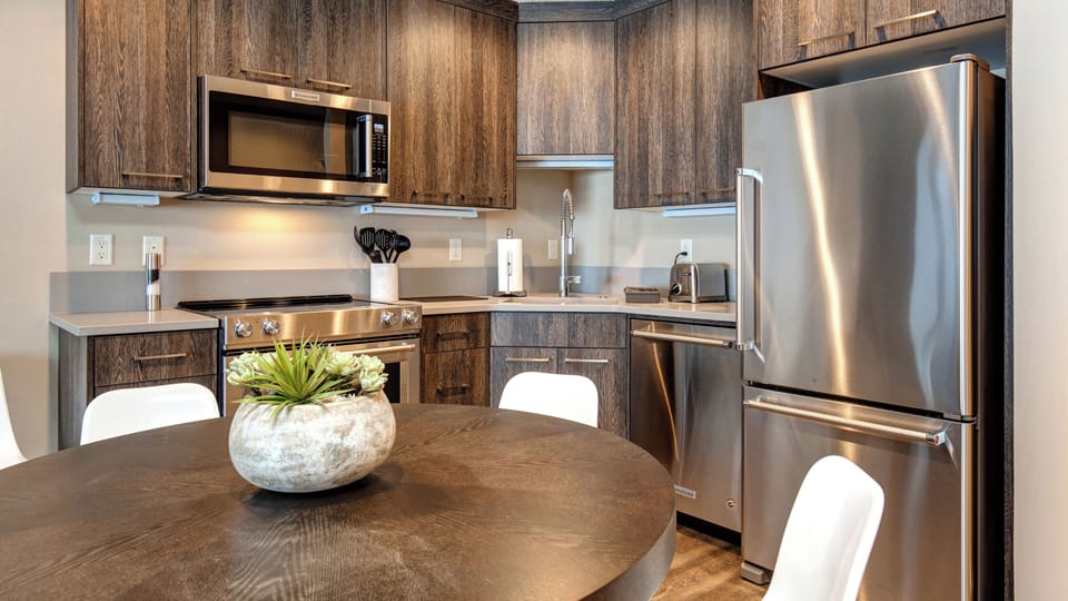 Step into your fully equipped kitchen with sleek stainless steel appliances, warm wood cabinetry, and plenty of counter space for preparing meals. Gather around the cozy dining table to enjoy your morning coffee or plan the day's adventures.