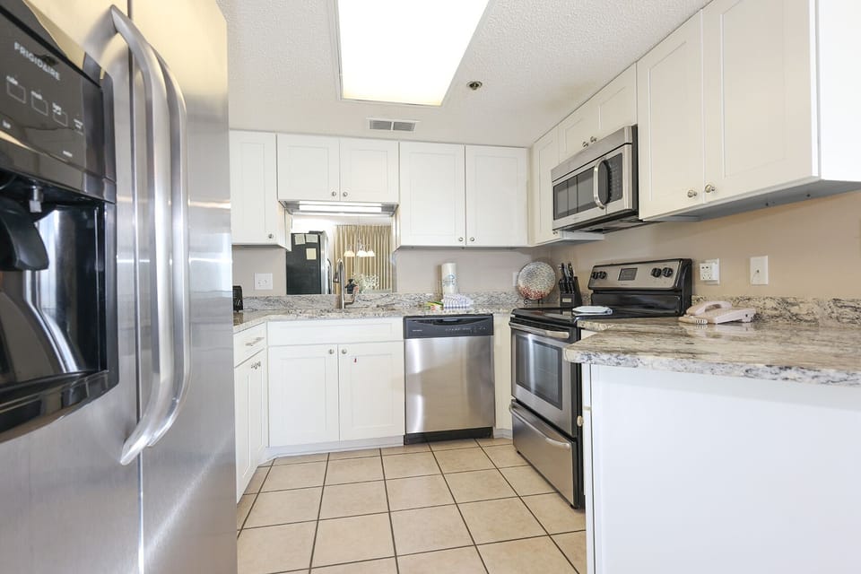 Prepare meals in this kitchen, featuring stainless appliances and stylish granite countertops