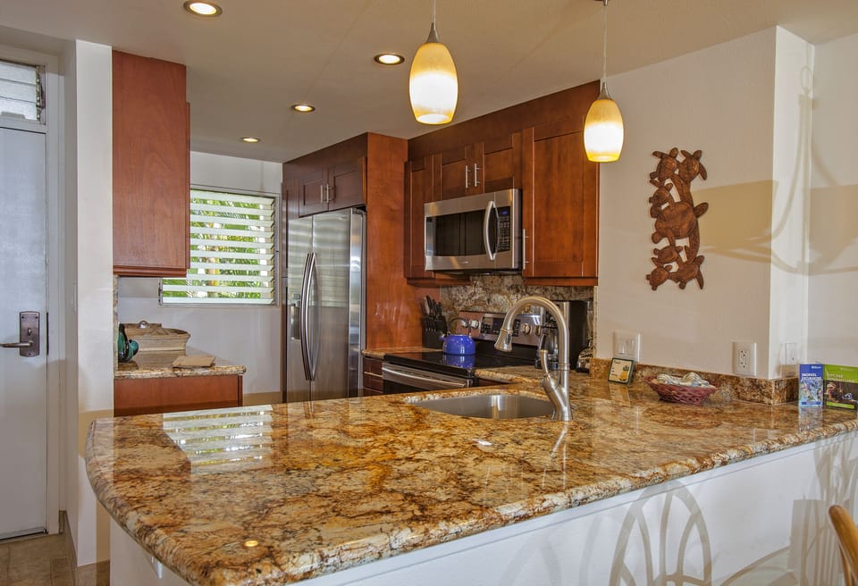 Step into your spacious chef's kitchen with gleaming granite counters and modern stainless appliances ready for preparing memorable meals during your island getaway.