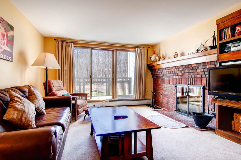The living room and fireplace w/ a flat screen TV