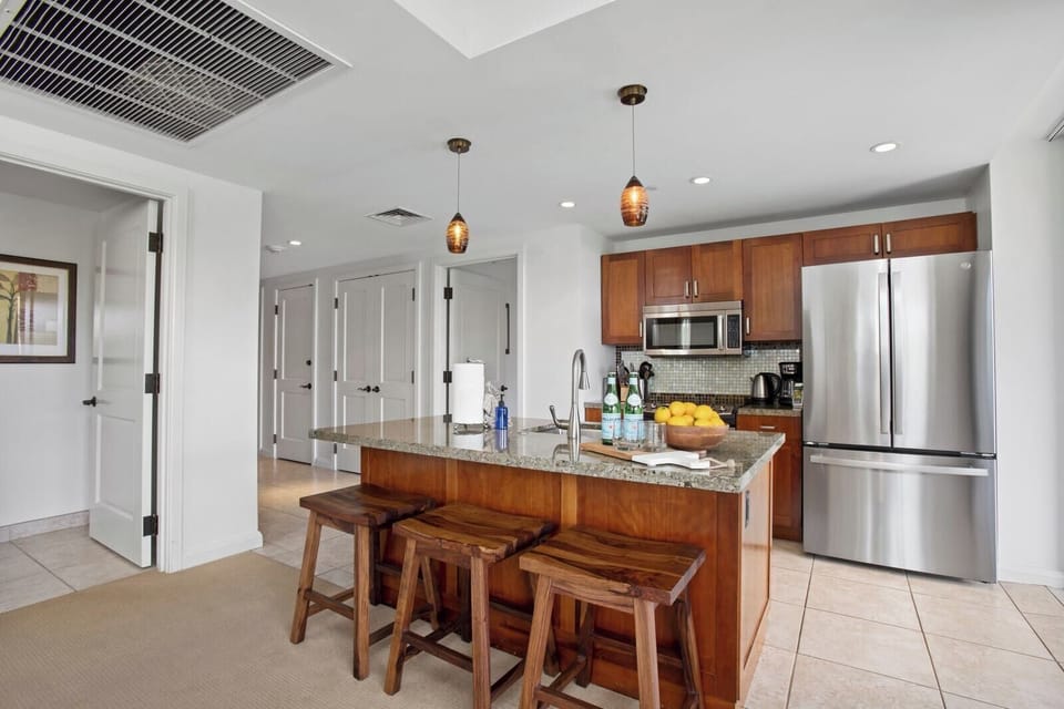 Modern island kitchen with granite counters and warm wood touches and functionality for everything you'll need