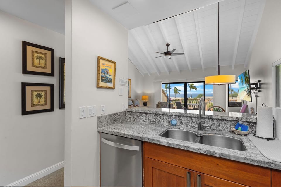 Your vacation kitchen opens to palm-fringed ocean views, blending coastal charm with modern convenience. Prepare meals under vaulted ceilings where tropical breezes flow through.