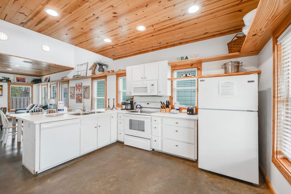 Your spacious kitchen invites culinary adventures with gleaming appliances, exposed wood beams, and ample counter space for memorable meals together.