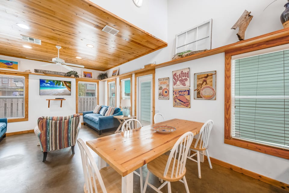 Gather around your rustic dining table in this warm, wood-accented space where coastal charm meets comfort for memorable meals.