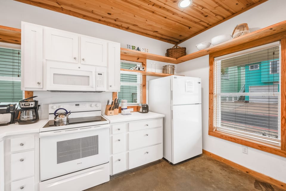 Your fully equipped kitchen features white appliances and warm wood accents, perfect for preparing meals during your stay.