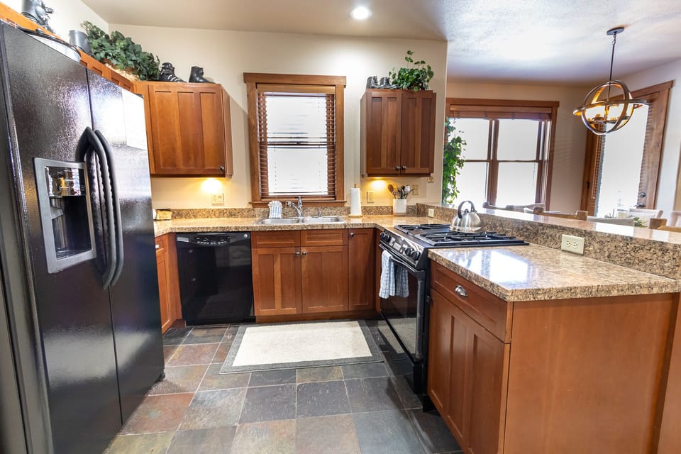 Your spacious kitchen features granite countertops, stainless steel appliances, and warm wood cabinets - perfect for preparing home-cooked meals during your stay.
