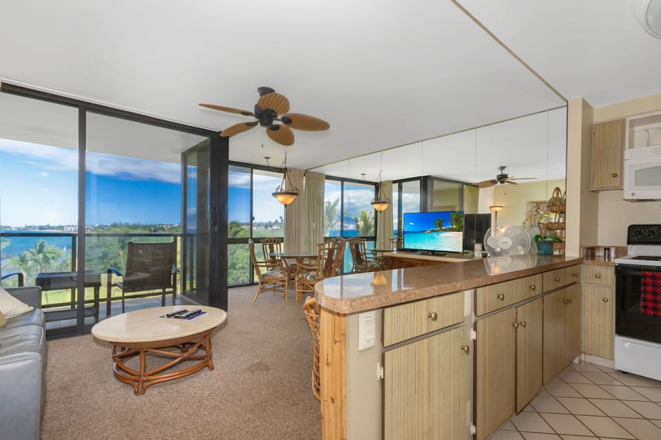 Your open-concept retreat blends island-inspired comfort with stunning views, where natural light pours through floor-to-ceiling windows and tropical breezes drift across the living and dining spaces.