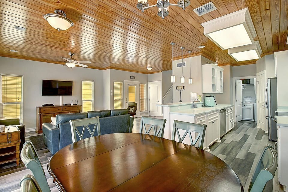Gather around your spacious dining table beneath warm wood ceilings, while the open kitchen invites culinary adventures and cozy conversations flow naturally.