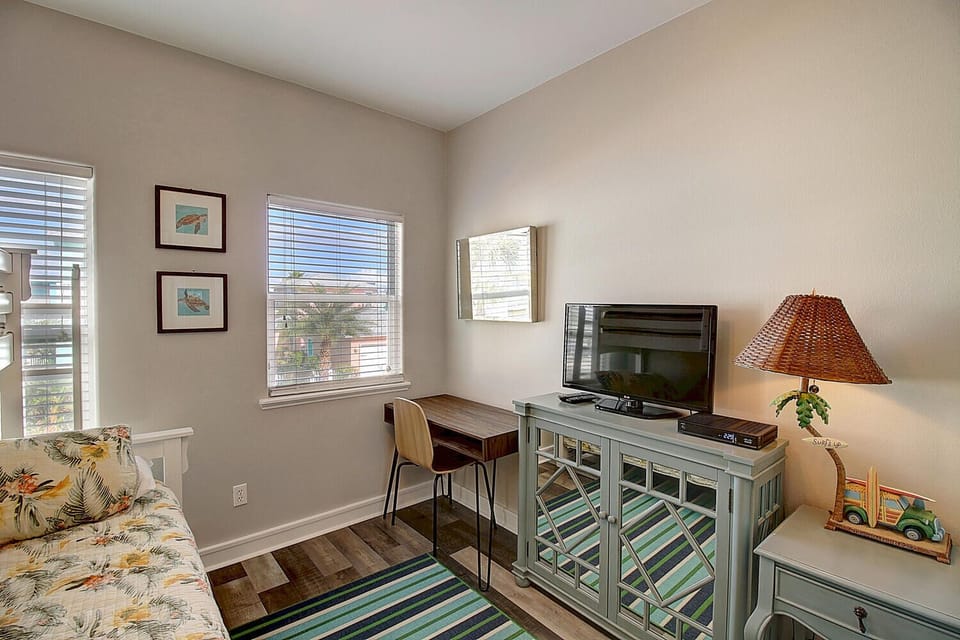 Settle into your bright workspace corner with tropical-print seating, dedicated desk area, and entertainment center for productive days and relaxing evenings.