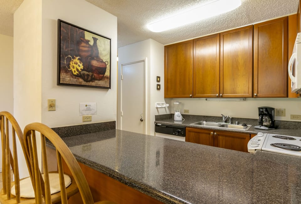 Your fully-equipped kitchen with granite counters, modern appliances, and cozy breakfast bar invites leisurely mornings and easy meal prep during your stay.