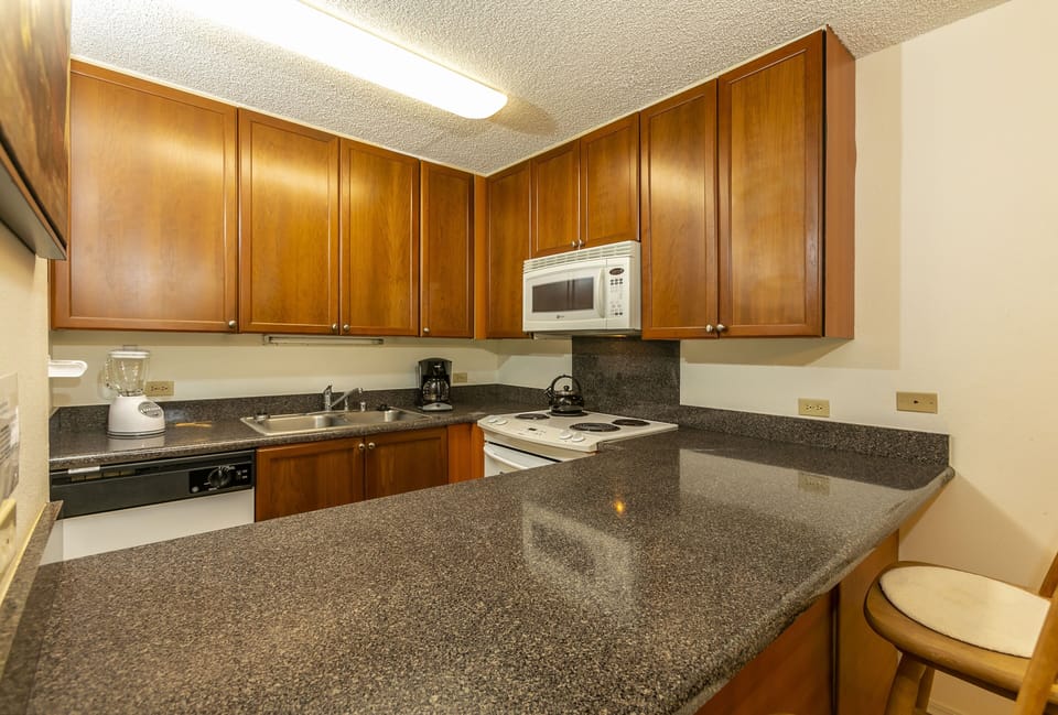 Your fully equipped kitchen offers ample counter space, modern appliances, and warm wood cabinetry—perfect for preparing meals and gathering with loved ones during your stay.