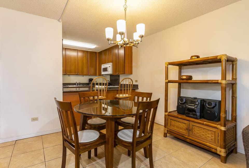 Gather around the warm wood dining table for meals and memories, with your fully equipped kitchen just steps away—perfect for cooking and entertaining during your stay.