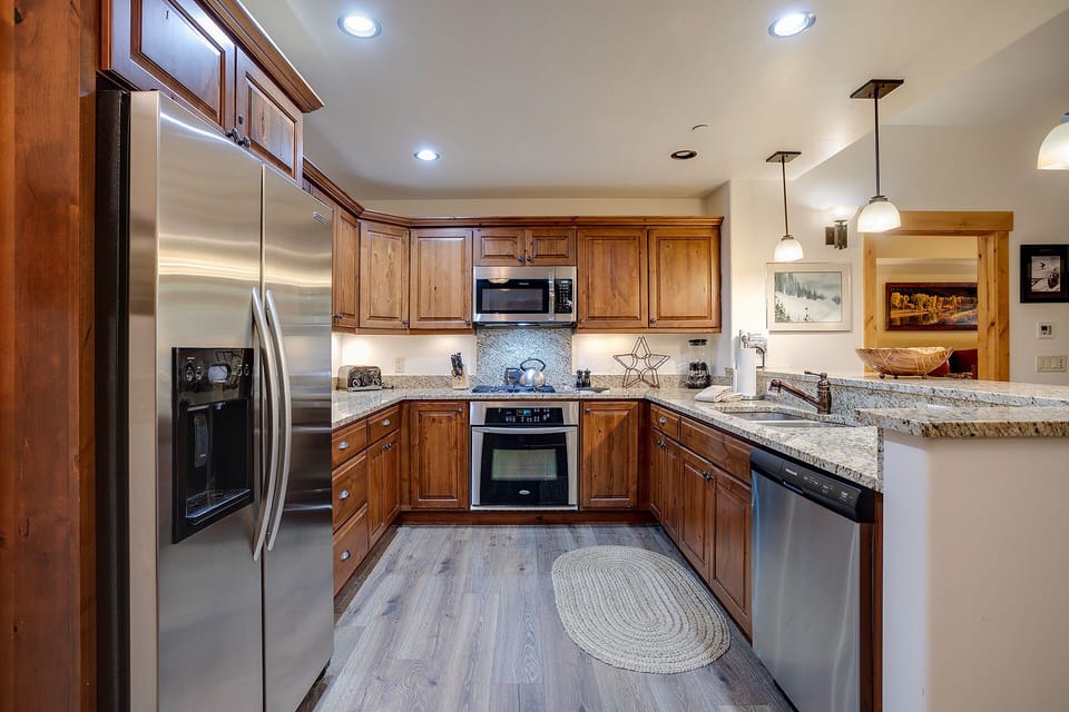 You'll love cooking in this fully equipped kitchen with granite countertops, stainless steel appliances, and warm wood cabinetry.