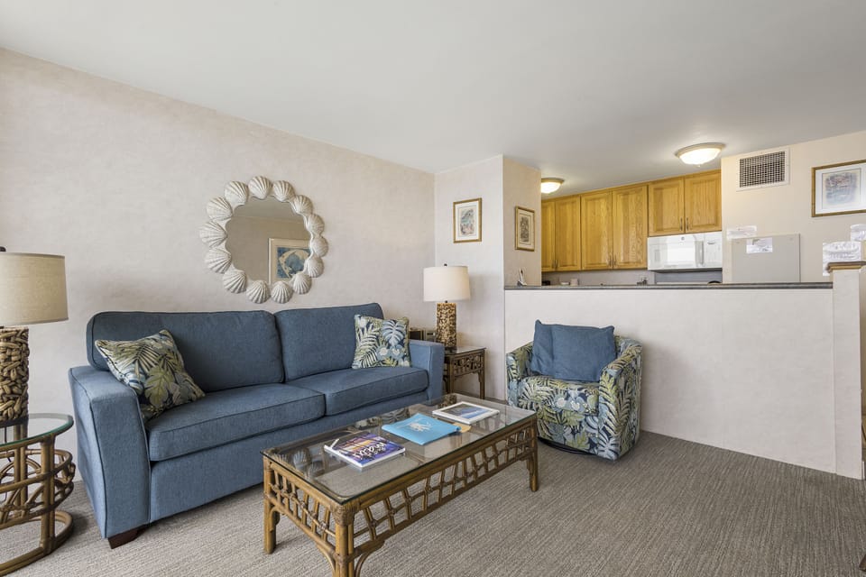 Unwind in your cozy living room with soft seating and beachy accents. Behind the half wall, your fully equipped kitchen awaits your vacation cooking adventures.