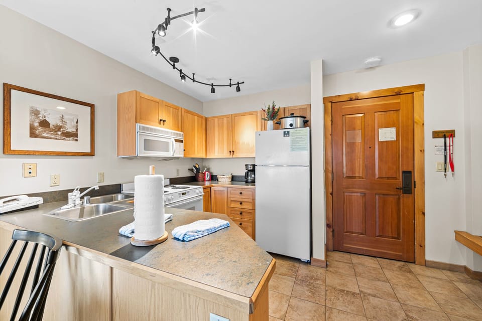 Your fully equipped kitchen features warm wood cabinetry, modern appliances, and ample counter space for preparing meals during your stay.
