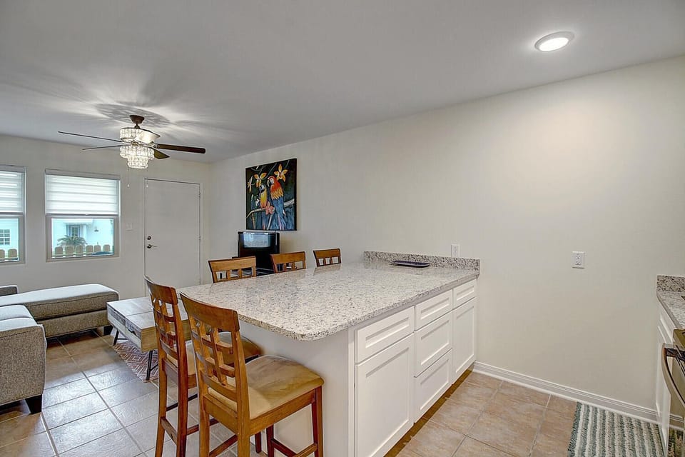 Your open kitchen island becomes the heart of gathering, with granite counters and warm wood seating perfect for morning coffee or evening conversations.