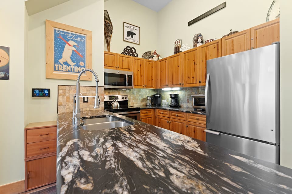 Your fully equipped kitchen features stunning granite countertops, stainless steel appliances, and warm wood cabinetry—perfect for preparing meals after a day of mountain adventures.