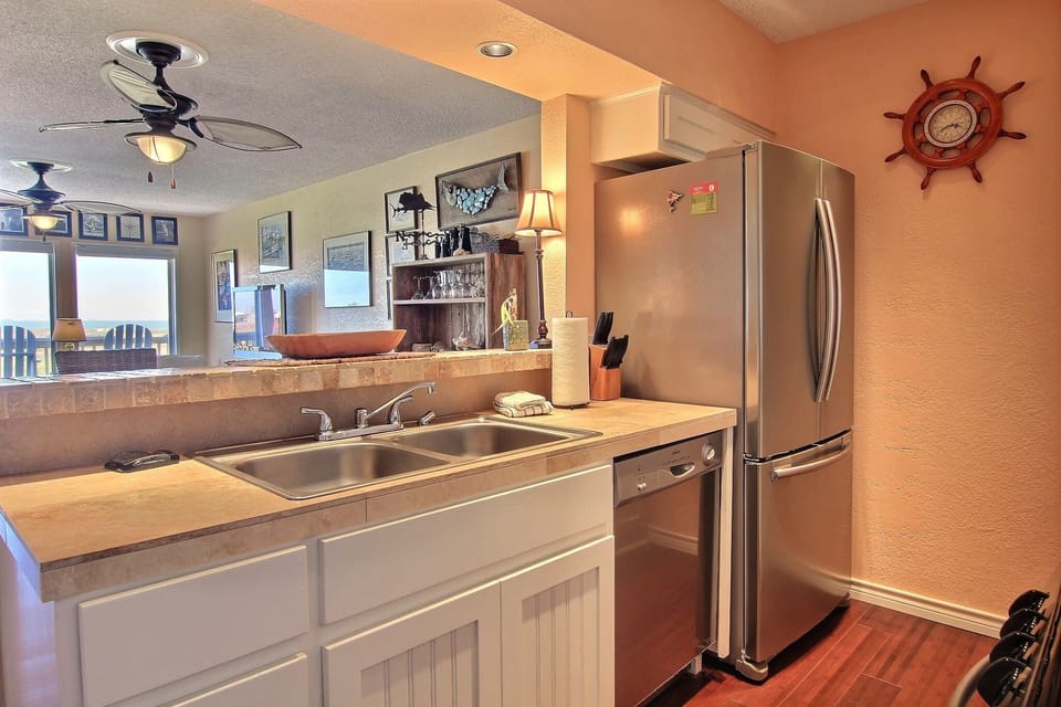 Your fully equipped kitchen features stainless steel appliances and warm coastal charm, perfect for preparing memorable meals during your stay.