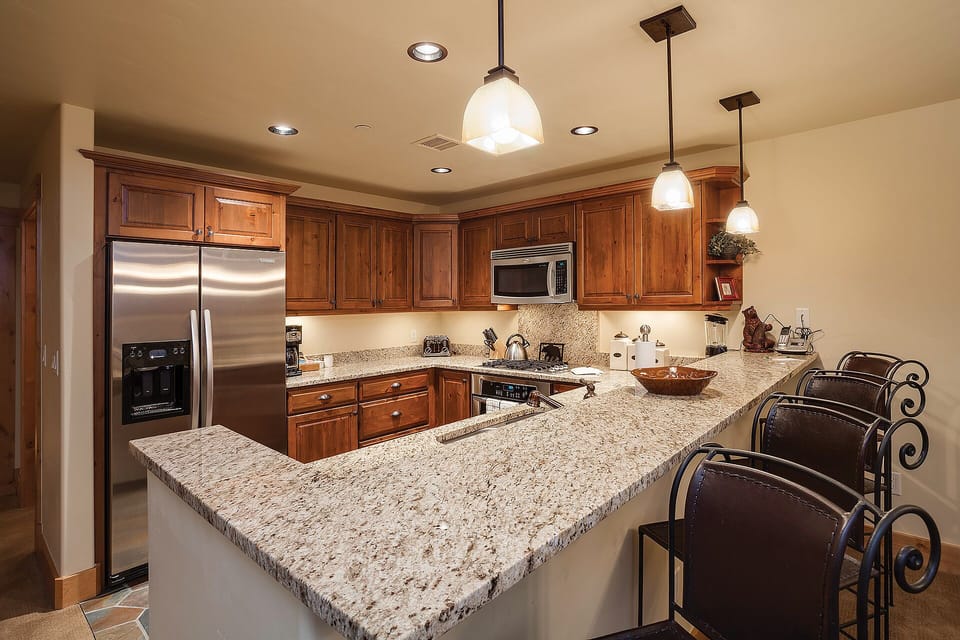 Your fully equipped kitchen awaits with granite countertops, stainless appliances, and a spacious island perfect for preparing memorable meals together.