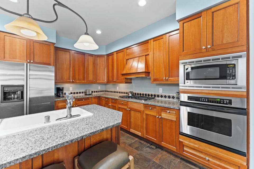 Your spacious gourmet kitchen awaits with granite counters, rich wood cabinets, and premium stainless appliances for memorable meal prep.