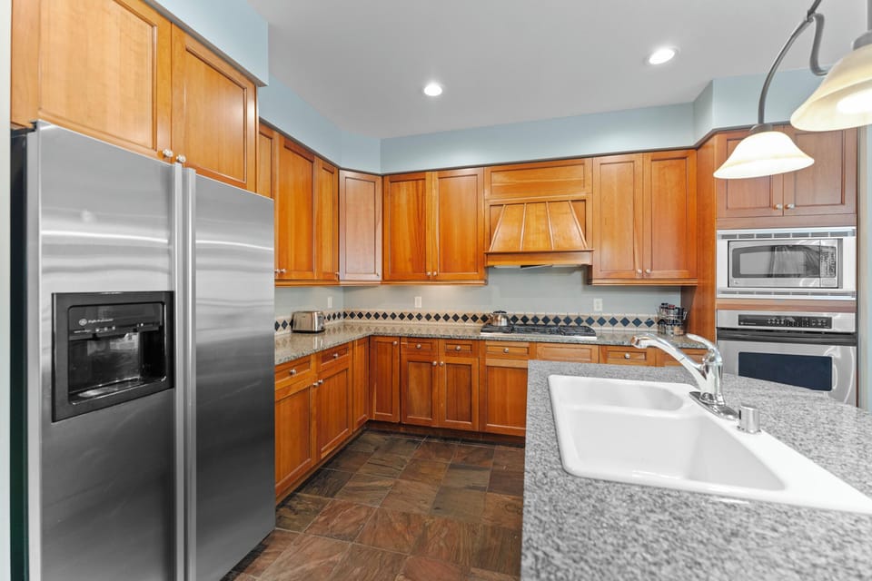 Your fully equipped kitchen features warm wood cabinets, granite countertops, and stainless steel appliances for all your culinary adventures.