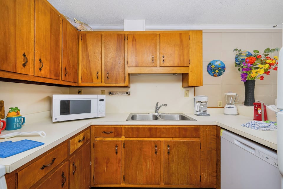 This kitchen features wooden cabinetry, a microwave, and colorful decor, creating a cheerful cooking space