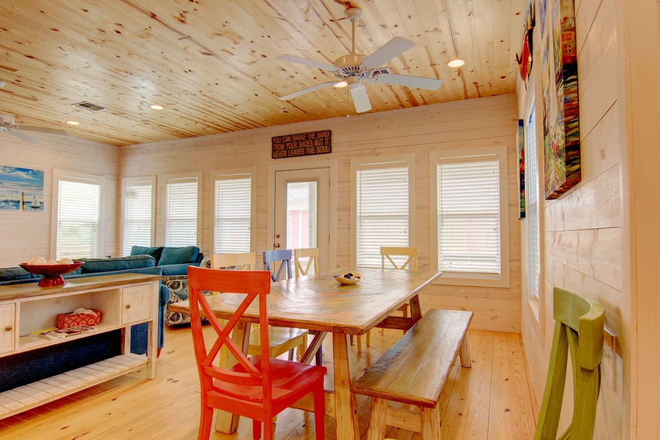 Gather around this charming wooden dining table where colorful chairs invite you to share meals and make memories in this bright, airy space.
