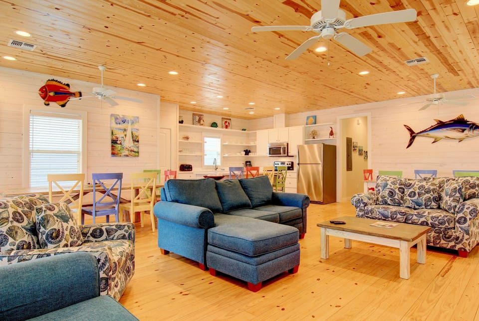 Relax in your spacious coastal-themed living room, where warm wood ceilings and nautical décor create the perfect retreat for family gatherings.
