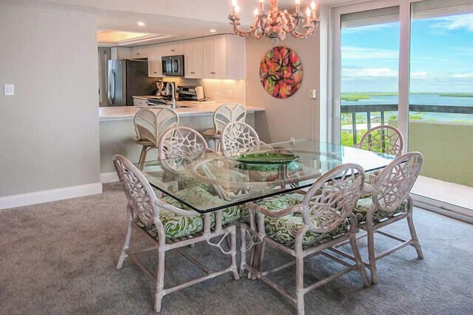 Glass topped dining table features a balcony view of the Bay
