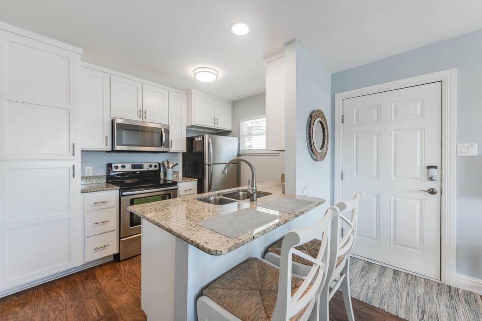 Your fully equipped kitchen features granite countertops, stainless steel appliances, and a cozy breakfast bar where you can enjoy morning coffee.